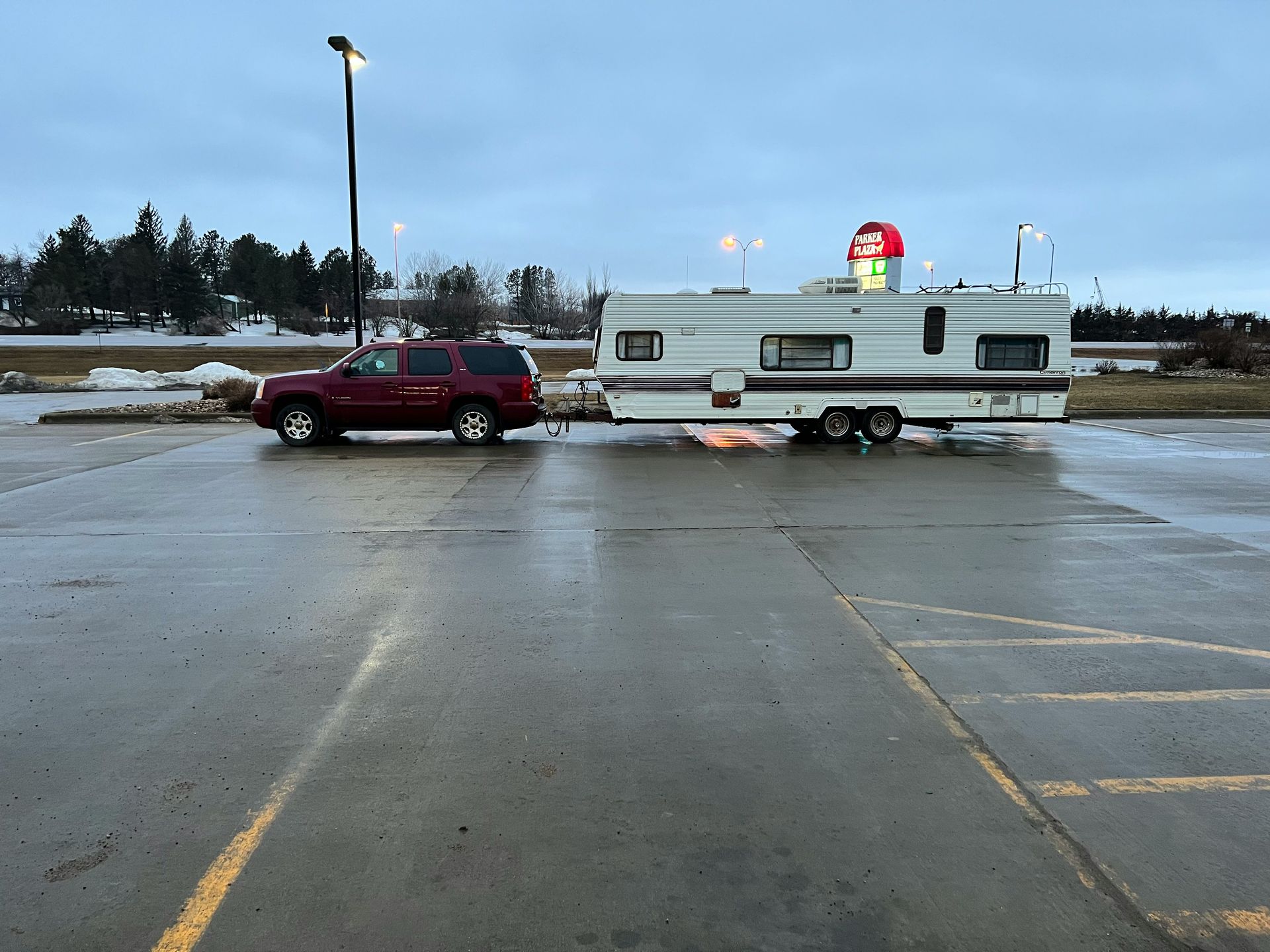 a red truck towing a trailer in a parking lot